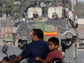 A NATO armored vehicle escorts a convoy of supply trucks Friday in Kabul, Afghanistan.