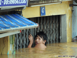 A man tries to get into his flooded house in Hoi An in the central Vietnamese province of Quang Nam.