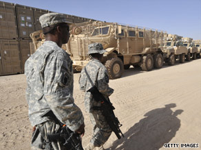 U.S. troops walk past a group of armored vehicles on Saturday at a military base in Afghanistan.
