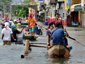 Residents paddle boats through the streets of Santa Cruz, south of Manila.