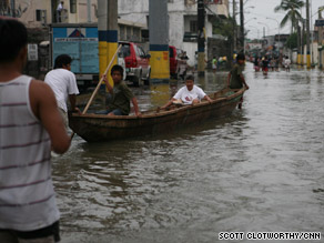 People use a canoe to cross floodwaters in Manila's Laguna de Bay neighborhood.