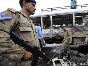 Pakistani troops inspect a bus damaged in a blast in Rawalpindi on July 2, 2009.