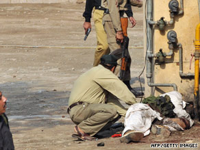 A bomb disposal squad member removes a suicide jacket from a body at the FIA in Lahore on Thursday.