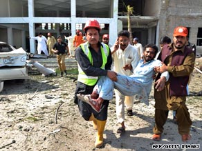 Rescuers carry an injured man from the site of the bomb blast in Pakistan.