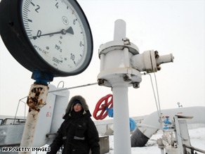 A woman passes in front of a manometer set on a gas pipe in the Ukrainian city of Boyarka, near Kiev.