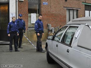 Police look at a hearse parked in front of the childcare centre in Dendermonde where the attack took place.