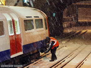 An underground worker attempts to release part of a tube train which had frozen in west London.