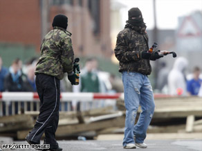Two people in masks prepare to throw petrol bombs in Lurgan, Northern Ireland.