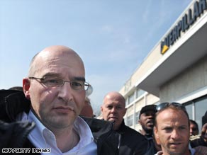 Caterpillar plant director Nicolas Polutnik (left) leaves the building after the 24-hour protest.