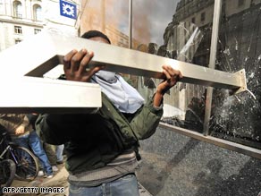 A protester smashes one of the Royal Bank of Scotland windows as scuffles threatened to escalate.