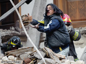 Rescue workers search for survivors in the ruins of a collapsed house in L'Aquila, Italy.