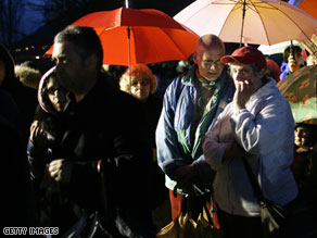 People cue in line to receive aid in L'Aqulia following Monday's earthquake.