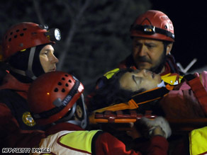 Rescue early Tuesday carry a survivor from the rubble in L'Aquila, Italy.