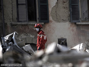 A rescue worker sifts through rubbe on Tuesday in L'Aquila, Italy.