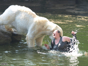 The bear attacks the woman during feeding time at the zoo.