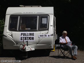 A voting clerk awaits voters outside a voiting station in Salisbury, southern England.