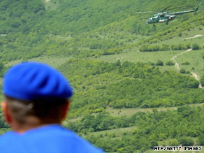 EU monitors watch a Russian helicopter flying near the border between Georgia and South Ossetia on July 29.