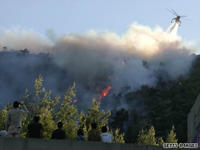 A firefighting helicopter drops water on a forest fire in the Athens suburb of Dionissii on sunday.