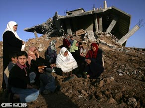 A Palestinian family sits Thursday amid ruins of their Gaza home, destroyed in Israel's strike against Hamas.