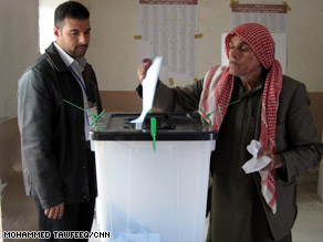 An Iraqi man whose finger has been ink stained after voting makes a call in Baghdad.