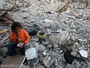 A Palestinian girl eats as she sits on the rubble of houses in Gaza on Wednesday.