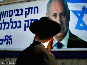 An orthodox Jewish man walks past a poster featuring Likud leader Benjamin Netanyahu.