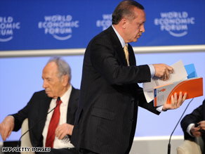 Recep Tayyip Erdogan leaves the stage at a conference last month as Shimon Peres sits, left.