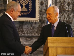 Netanyahu (left) shakes hands with Shimon Peres, who has asked him to form the next government.
