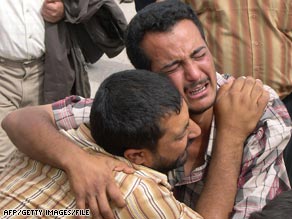 In April 2006, two Iraqis mourn a relative slain in sectarian violence in the city of Falluja.