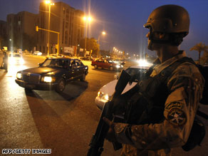 An Iraqi soldier mans a checkpoint as Iraqi troops battle Awakening Council members in Baghdad on Saturday.