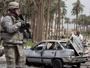 A U.S. soldier checks out the site of a car bomb attack Tuesday in a Shiite district of Baghdad.