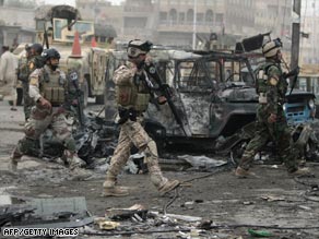 Iraqi soldiers survey one of the Baghdad marketplaces where car bombs detonated Wednesday.