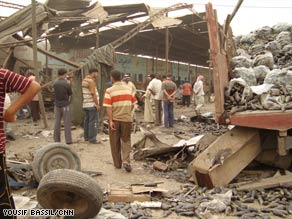 Iraqis look at damage from a bombing at a produce market in Baghdad on Wednesday.