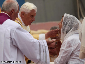 Pope Benedict XVI gives Communion to a Jordanian woman at a Mass in Amman, Jordan, on Sunday.