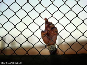 An Iraqi detainee grips a fence at Camp Cropper, one of the few U.S. detention centers remaining in Iraq.