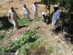 Pakistan residents cover a grave after burying a suspected Taliban militant, who was killed during fighting.