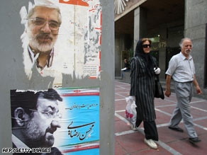 Iranians walk past campaign posters in Tehran ahead of Friday's ballot. 