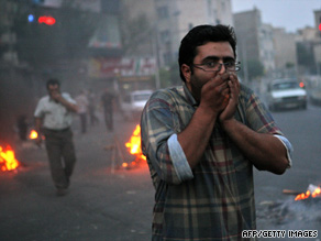 Protesters try to protect themselves from tear gas fired by police Saturday in Tehran. 
