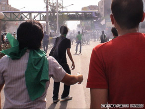 Protesters face Iranian riot police on a street in Tehran on Saturday.