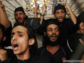 Al Qaeda suspects shout inside their courtroom cage during sentencing Monday in Yemen.