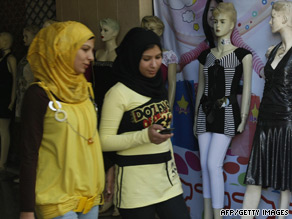 Palestinian Muslim women walk past a shop displaying Western clothes in Gaza City.