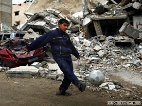 A Palestinian boy kicks a football outside damaged homes in northern Gaza in January 2009.