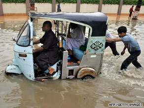 Merchants wade through water Karachi's Iqbal market, where silk and chiffon trade is conducted