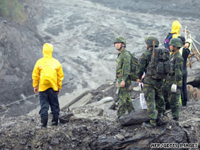 Rescuers and soldiers try to cross a swollen river in Kaohsiung County, Taiwan, on Wednesday.