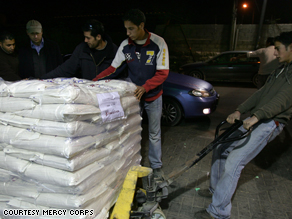Mercy Corps workers loading trucks with food and medical supplies.