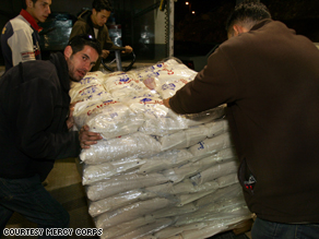 Mercy Corps workers preparing vehicles with humanitarian aid for delivery into Gaza.