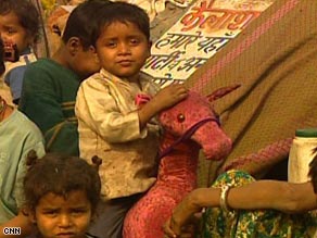 Homeless children play outside their destroyed huts.