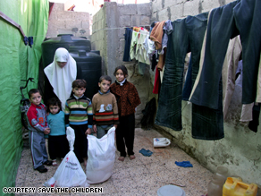 A widow and her children in Gaza after receiving food aid from Save the Children.