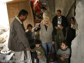 A Mercy Corp worker delivers aid to a family in Gaza.