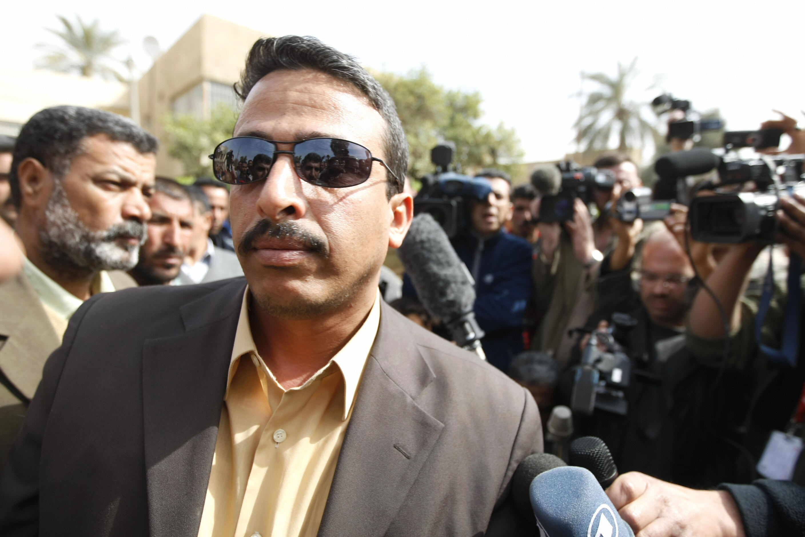 AHMAD AL-RUBAYE/AFP/Getty Images. Udai, the brother of jailed journalist Muntazer al-Zaidi, is surrounded by the press as he leaves the Central Criminal Court in Baghdad.